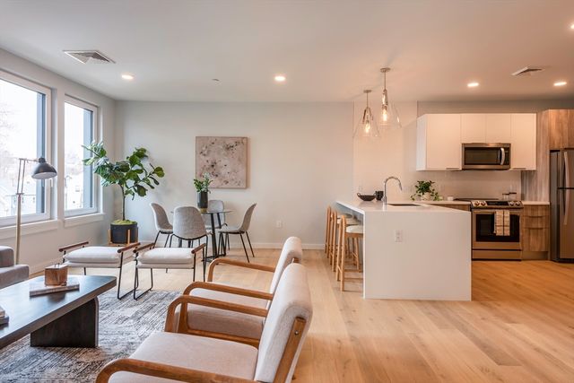 a living room with furniture and kitchen view