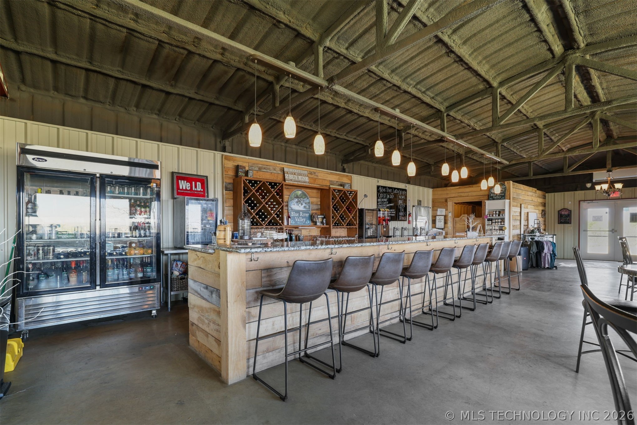 3565 Sawmill Road Caddo, OK 74729 - Photo 6 of 32 Exposed beam ceiling with pendant lighting, wood-finish bar, integrated wine rack, and a commercial beverage cooler