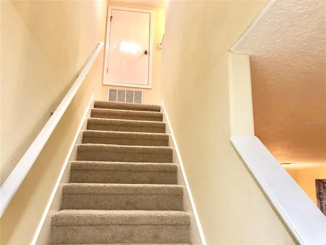 a view of staircase with wooden floor and white walls