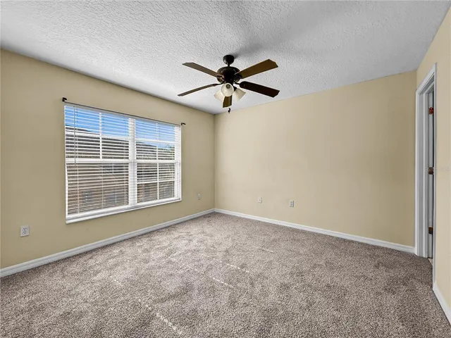 an empty room with a window and a fan