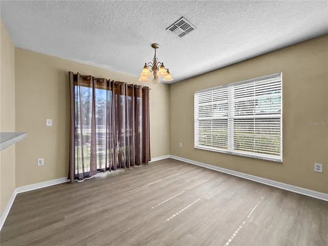 a view of an empty room with glass door and wooden floor