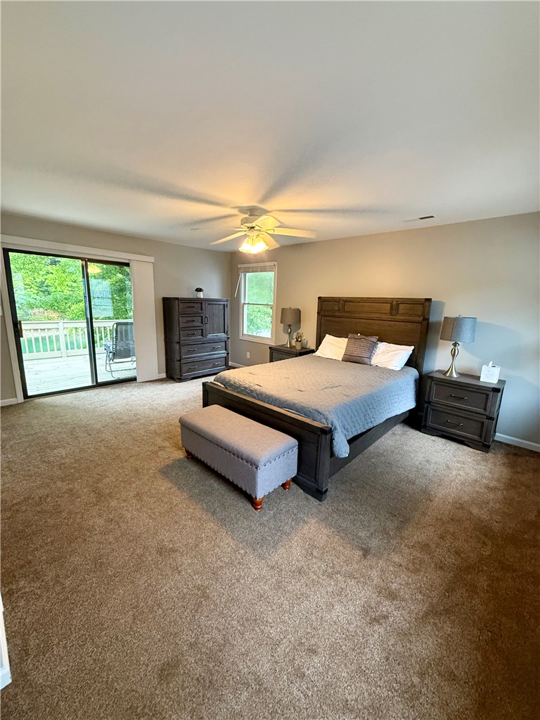 1200 Loran Pointe Circle Seneca, SC 29672 - Photo 9 of 29 This primary bedroom features plush carpeting and a private deck, offering a serene escape.