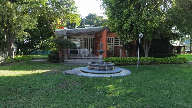 a view of house with a backyard