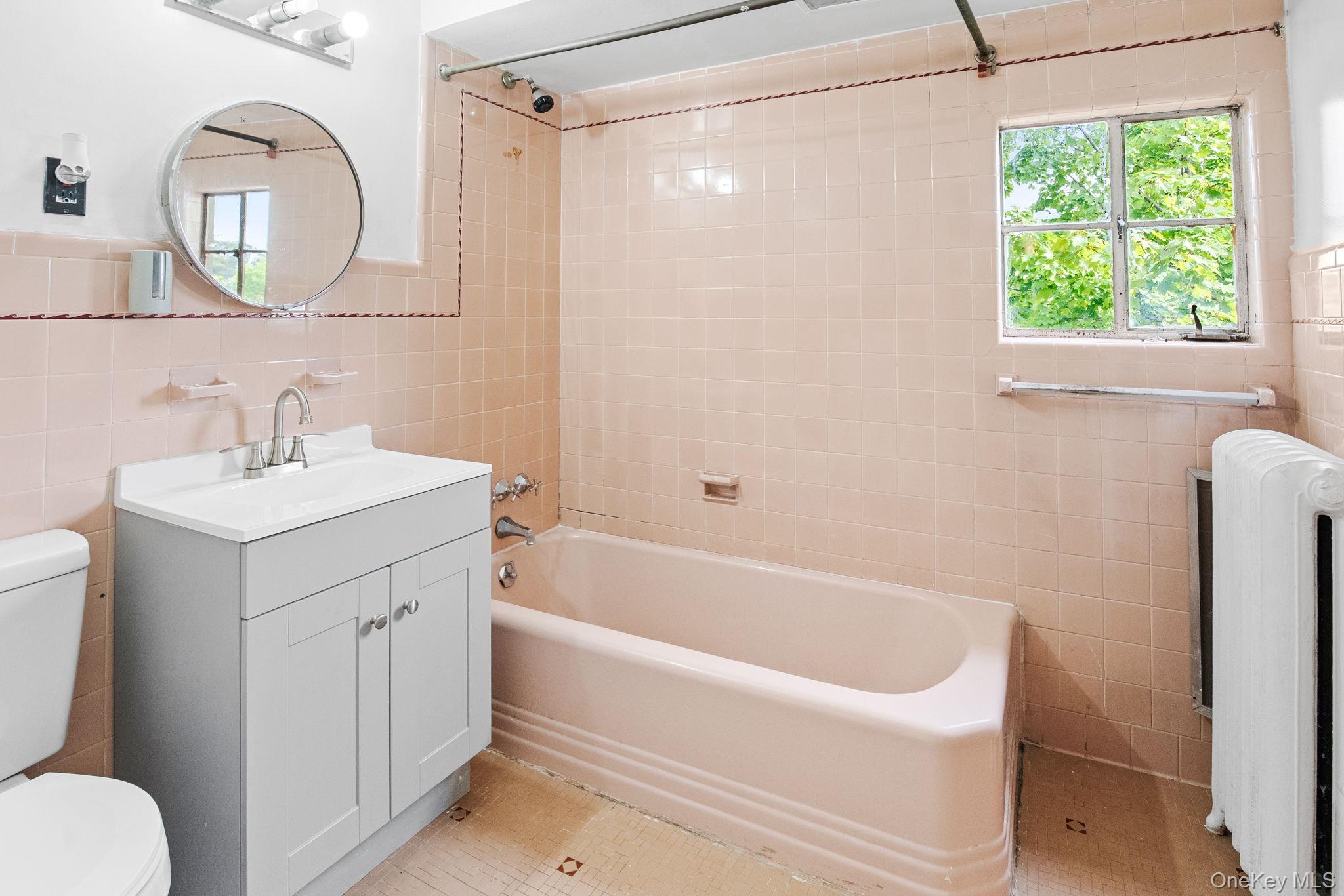 72 Hamilton Avenue New Rochelle, NY 10801 - Photo 13 of 28 a bathroom with a tub a sink and a mirror