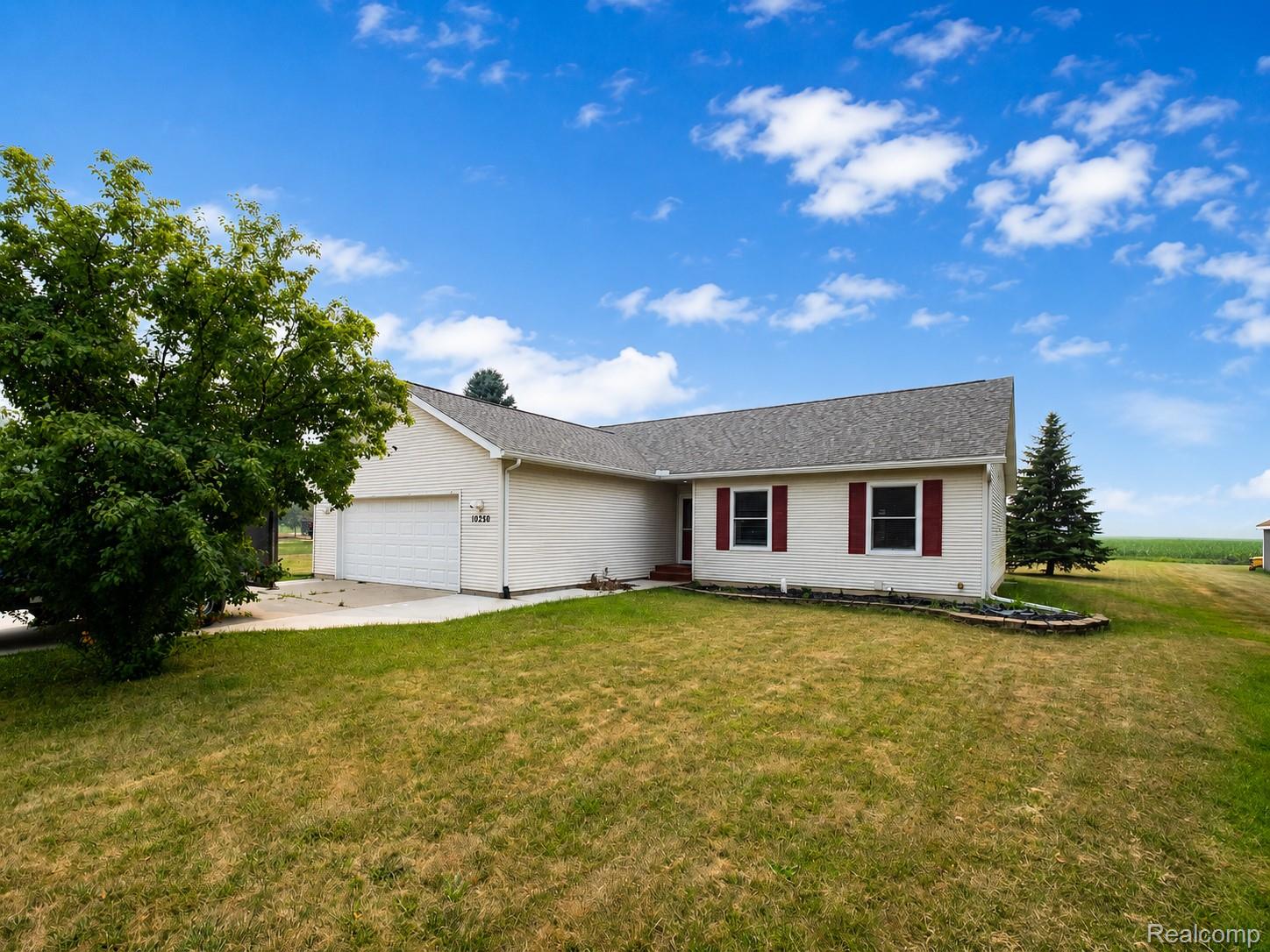 10250 Duffield Road Gaines, MI 48436 - Photo 1 of 28 Single-story exterior with attached garage, composition shingle roof, red window shutters, and a concrete driveway