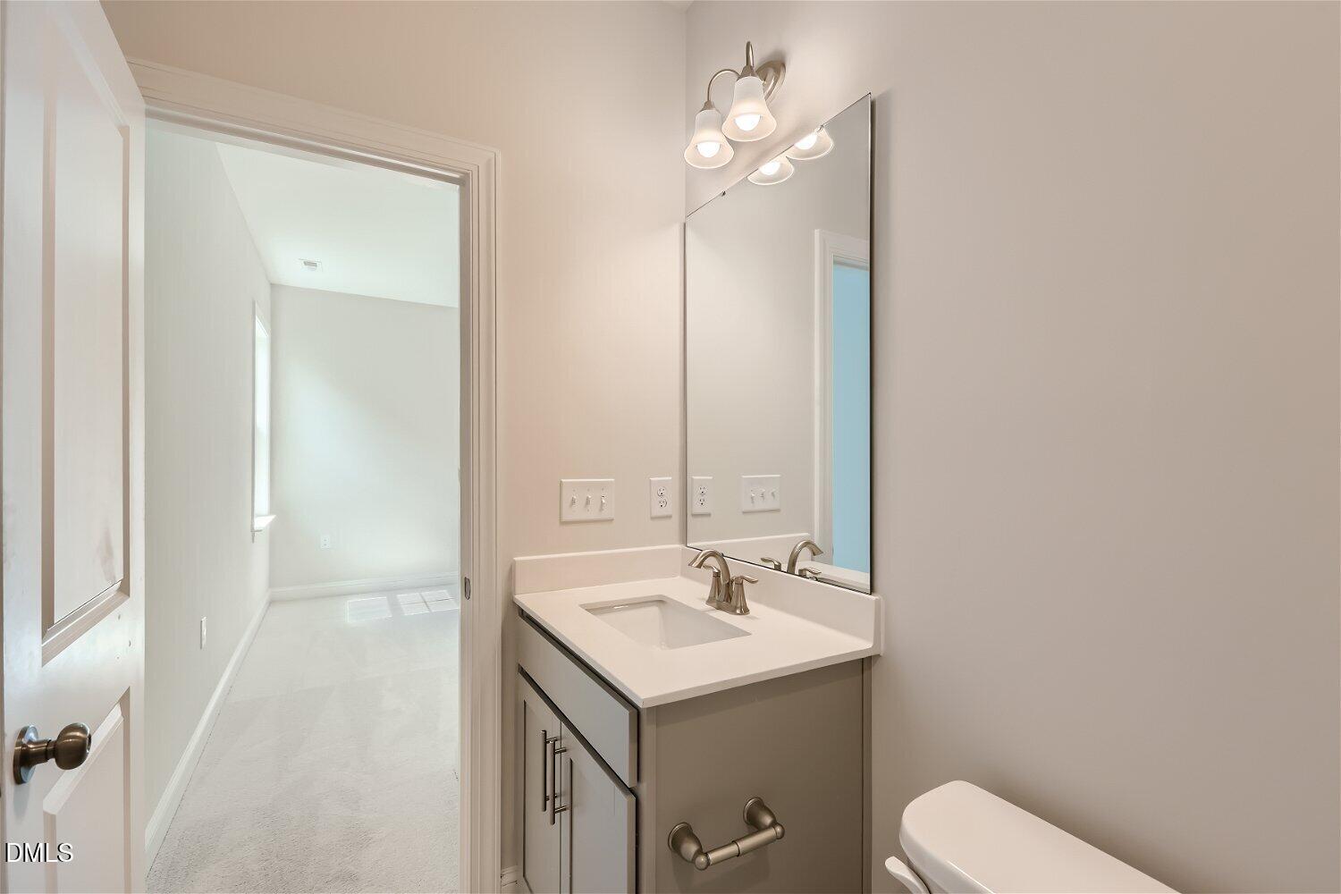 124 Fablewood Trail Garner, NC 27529 - Photo 7 of 27 a bathroom with a sink a toilet and mirror