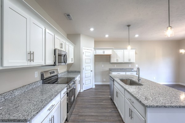 21 Bartow Street Decherd, TN 37324 - Photo 14 of 30 a kitchen with stainless steel appliances granite countertop a sink stove and refrigerator