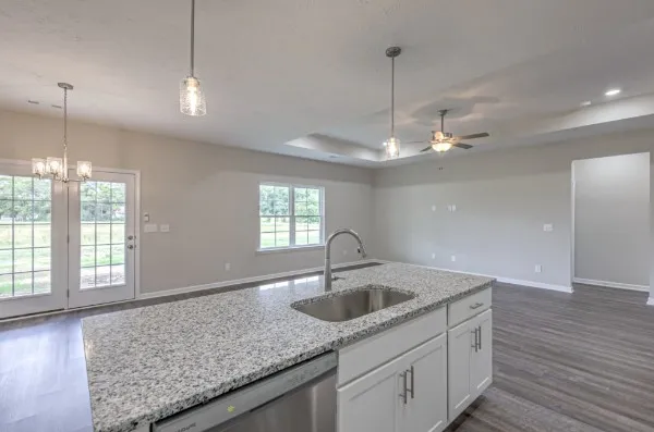 a kitchen with kitchen island wooden floors stainless steel appliances and cabinets