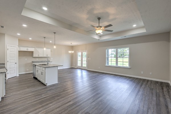 21 Bartow Street Decherd, TN 37324 - Photo 21 of 30 an open kitchen with white cabinets wooden floor and a kitchen island