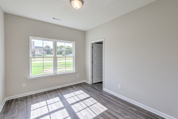 21 Bartow Street Decherd, TN 37324 - Photo 6 of 30 an empty room with wooden floor and windows
