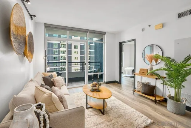 a living room with furniture a rug and a floor to ceiling window