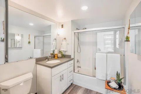 a bathroom with a granite countertop sink a toilet and a shower