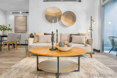 a living room with a table or chairs a potted plant and wooden floor