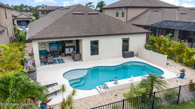 a view of a house with pool and sitting area