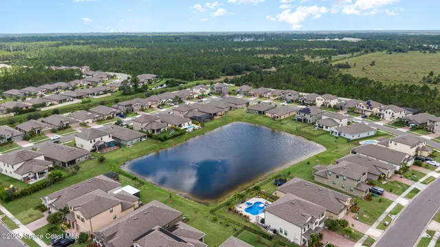 an aerial view of a city with lots of residential buildings and mountain view in back