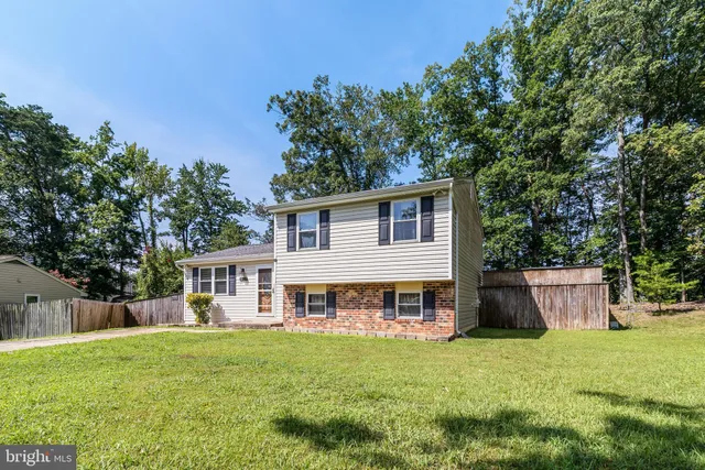 a view of house with backyard and a garden