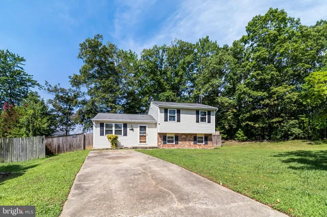 a front view of a house with a yard and potted plants