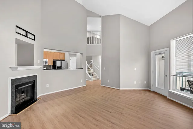 a view of a livingroom with wooden floor and staircase