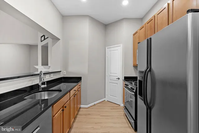 a kitchen with granite countertop stainless steel appliances a sink and cabinets