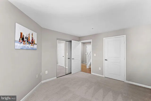 a view of an empty room with chandelier fan and fire place