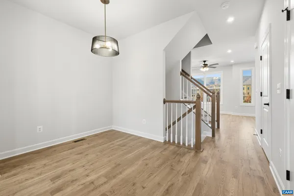 a kitchen with stainless steel appliances granite countertop a refrigerator a sink a stove and a wooden floors