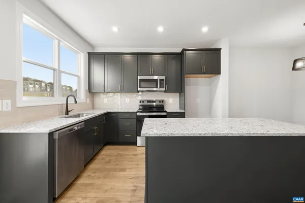 a kitchen with granite countertop a stove and a refrigerator