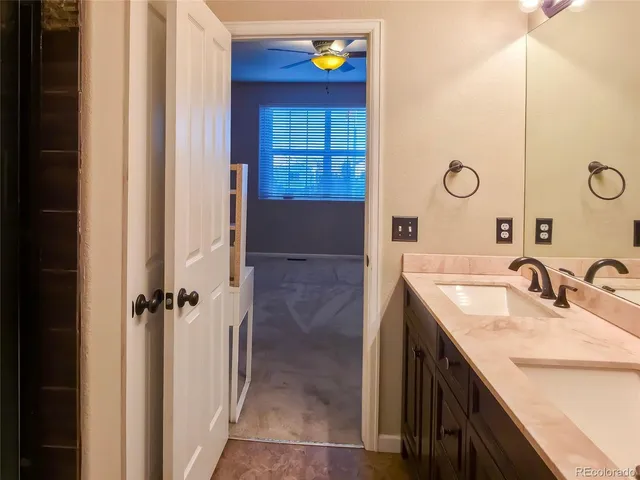 a bathroom with a granite countertop sink a mirror a vanity and a shower