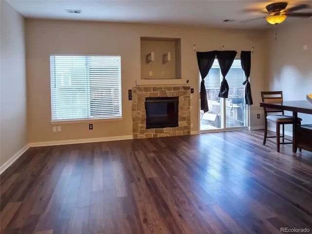 a view of empty room with wooden floor and fireplace