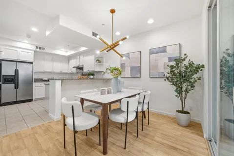 a kitchen with stainless steel appliances kitchen island a table and chairs in it