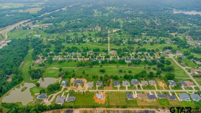 an aerial view of residential houses with outdoor space and trees