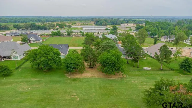 a view of green field with trees in the background