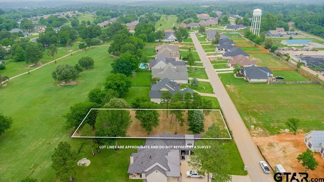 an aerial view of residential houses with outdoor space and trees