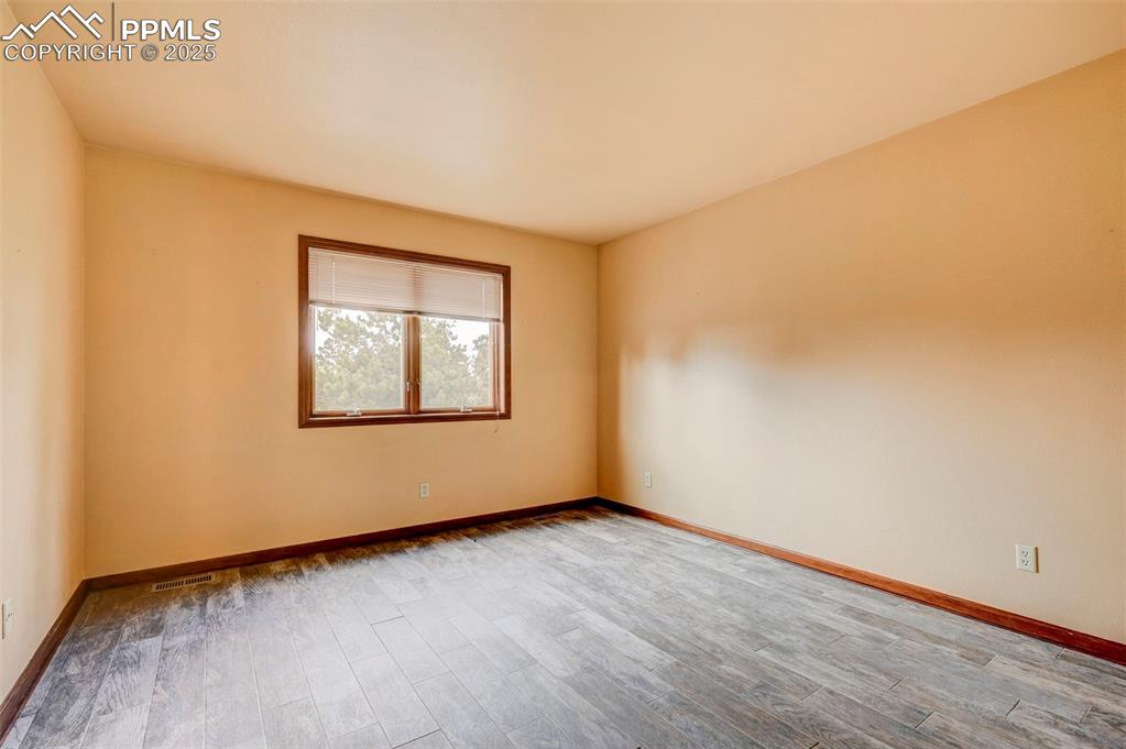 6290 Old Ranch Road Colorado Springs, CO 80908 - Photo 40 of 48 an empty room with wooden floor and windows