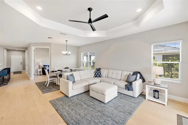 a dining room with furniture a chandelier and wooden floor