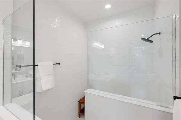 a bathroom with a sink mirror and shower