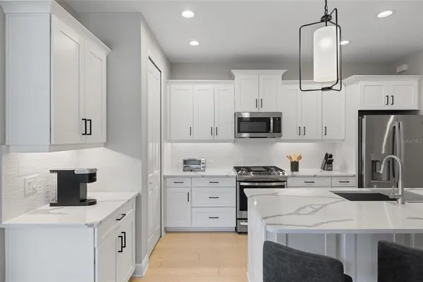 a kitchen with stainless steel appliances a stove sink microwave and cabinets