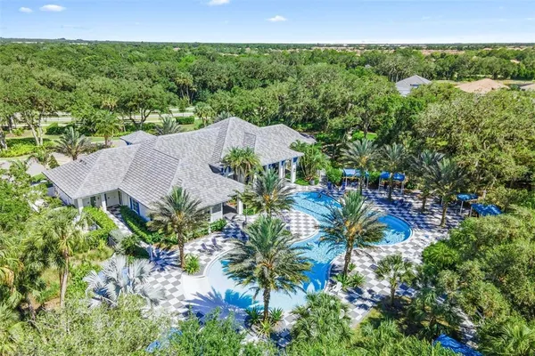 an aerial view of residential houses with outdoor space and trees