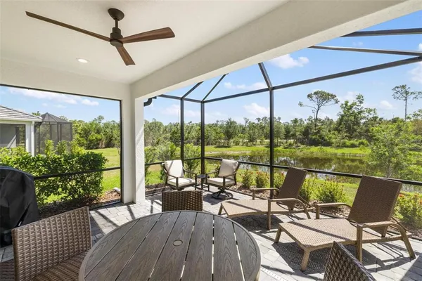 a living room with patio furniture and a floor to ceiling window
