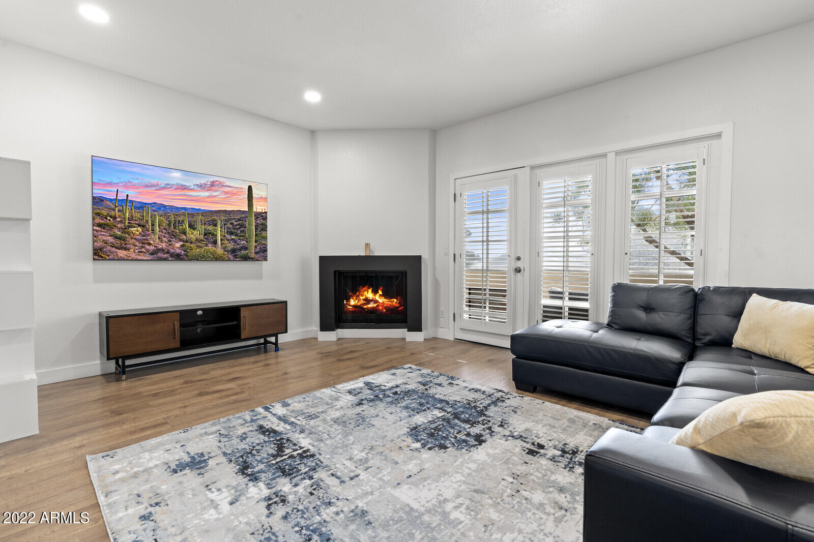 3047 East Rose Lane Phoenix, AZ 85016 - Photo 4 of 27 a living room with furniture a flat screen tv and a fireplace