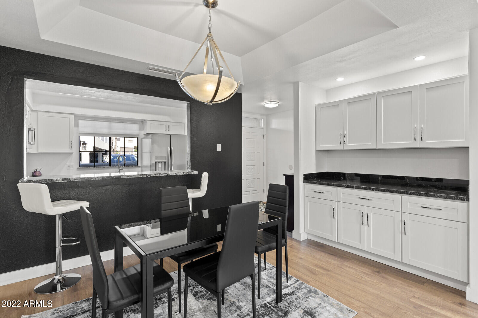 3047 East Rose Lane Phoenix, AZ 85016 - Photo 5 of 27 a kitchen with a dining table chairs cabinets and stainless steel appliances