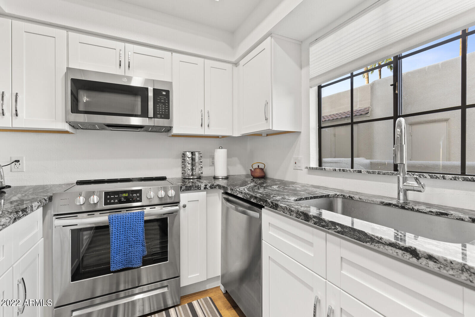 3047 East Rose Lane Phoenix, AZ 85016 - Photo 8 of 27 a kitchen with granite countertop a sink and a stove top oven
