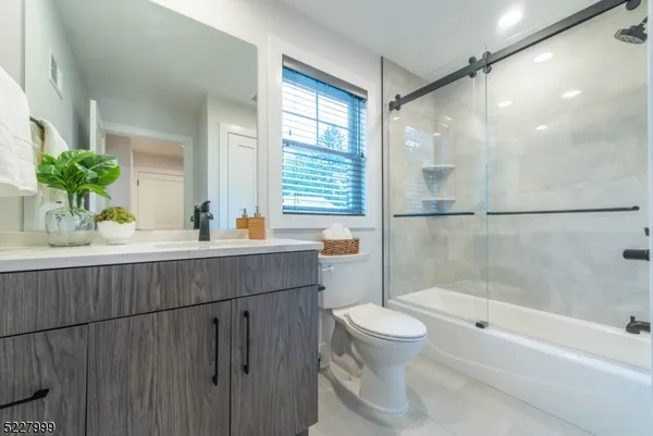 a bathroom with a granite countertop sink a toilet and shower