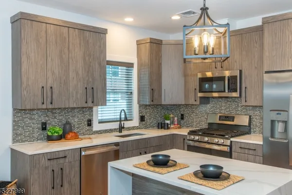 a kitchen with stainless steel appliances a stove a sink a refrigerator and cabinets