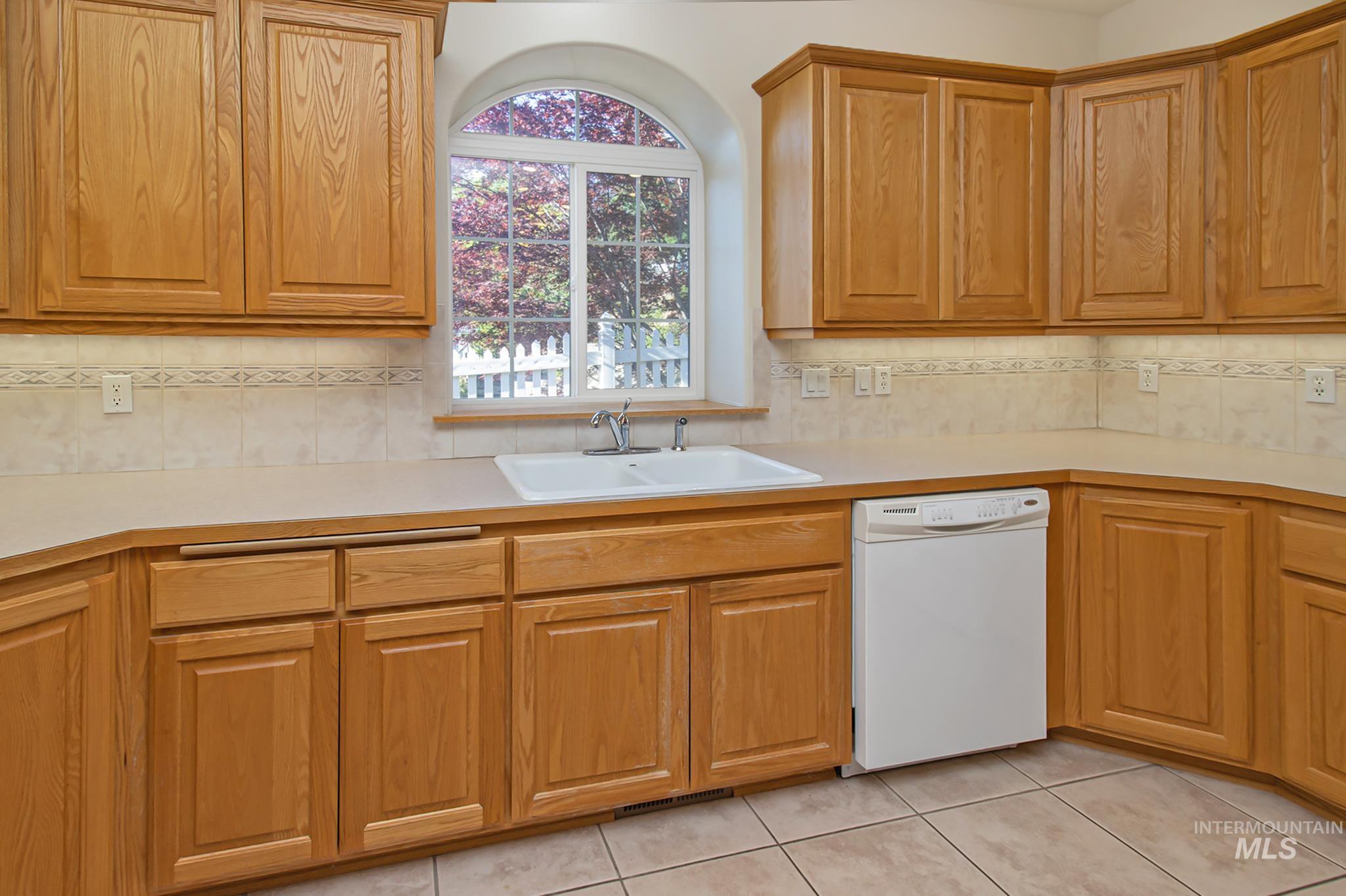 2133 13th Street Lewiston, ID 83501 - Photo 11 of 38 Kitchen featuring light wood cabinetry, a double basin sink, and an arched window