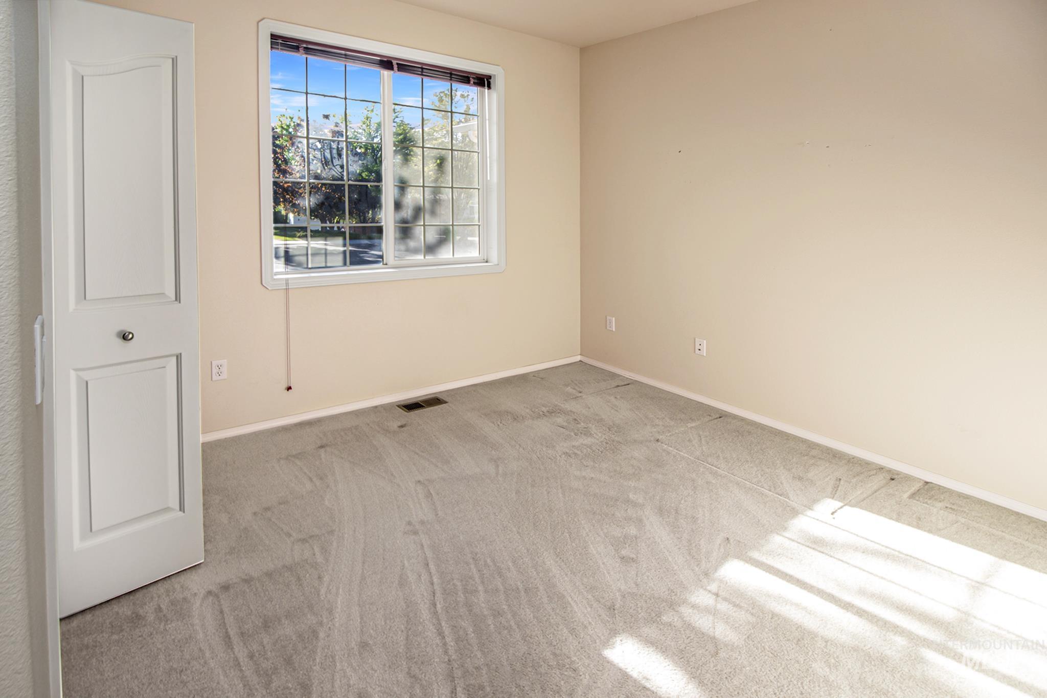 2133 13th Street Lewiston, ID 83501 - Photo 20 of 38 Carpeted room featuring a double-pane window with grid inserts, beige wall paint, white trim, and a white interior door