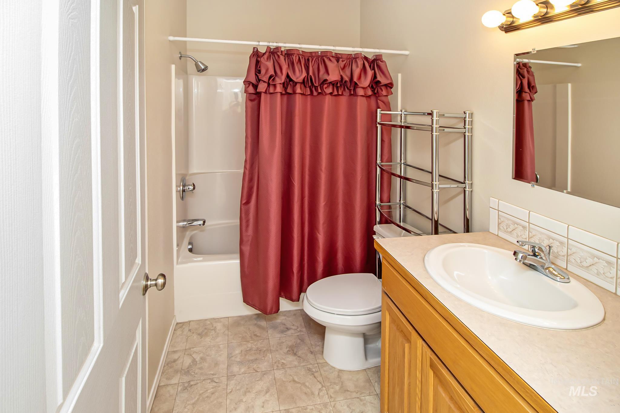 2133 13th Street Lewiston, ID 83501 - Photo 22 of 38 Bathroom featuring a wood-finish vanity with an integrated sink, a large mirror, and overhead vanity lighting