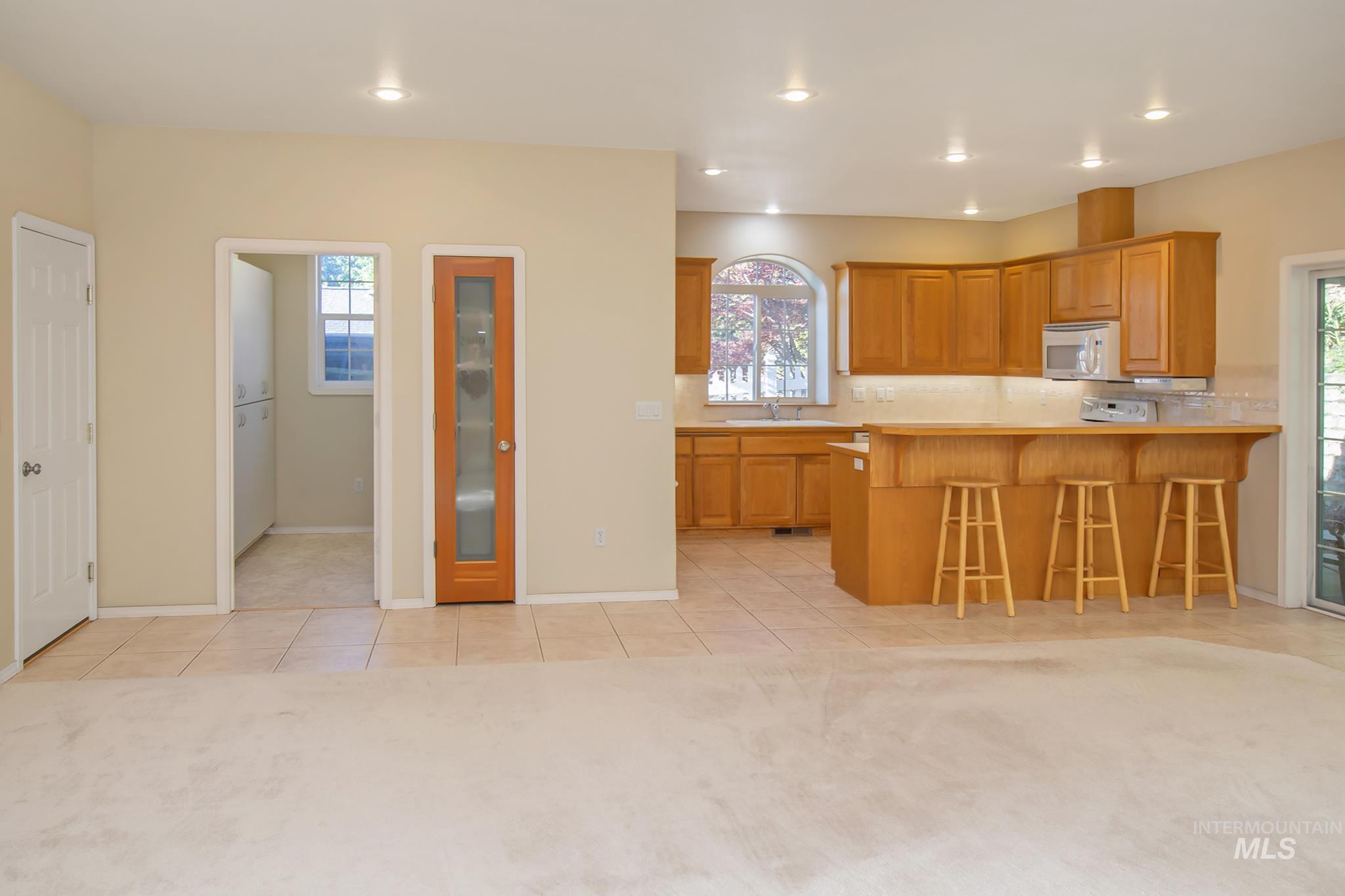 2133 13th Street Lewiston, ID 83501 - Photo 5 of 38 Open-concept living space featuring a kitchen with wood cabinetry, a breakfast bar, and tile flooring