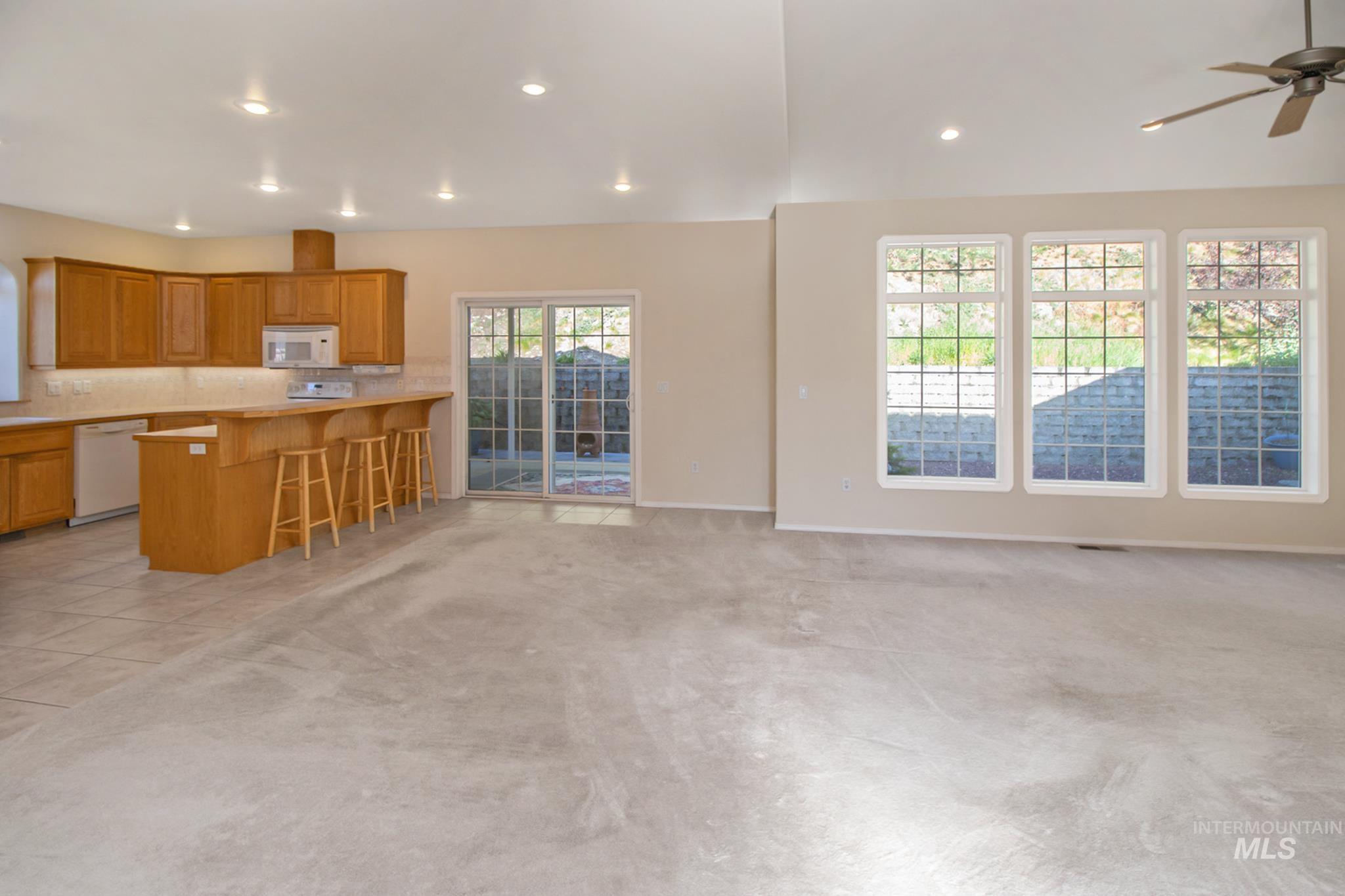 2133 13th Street Lewiston, ID 83501 - Photo 7 of 38 Open concept space featuring light wood cabinetry, white appliances, a breakfast bar, and recessed lighting