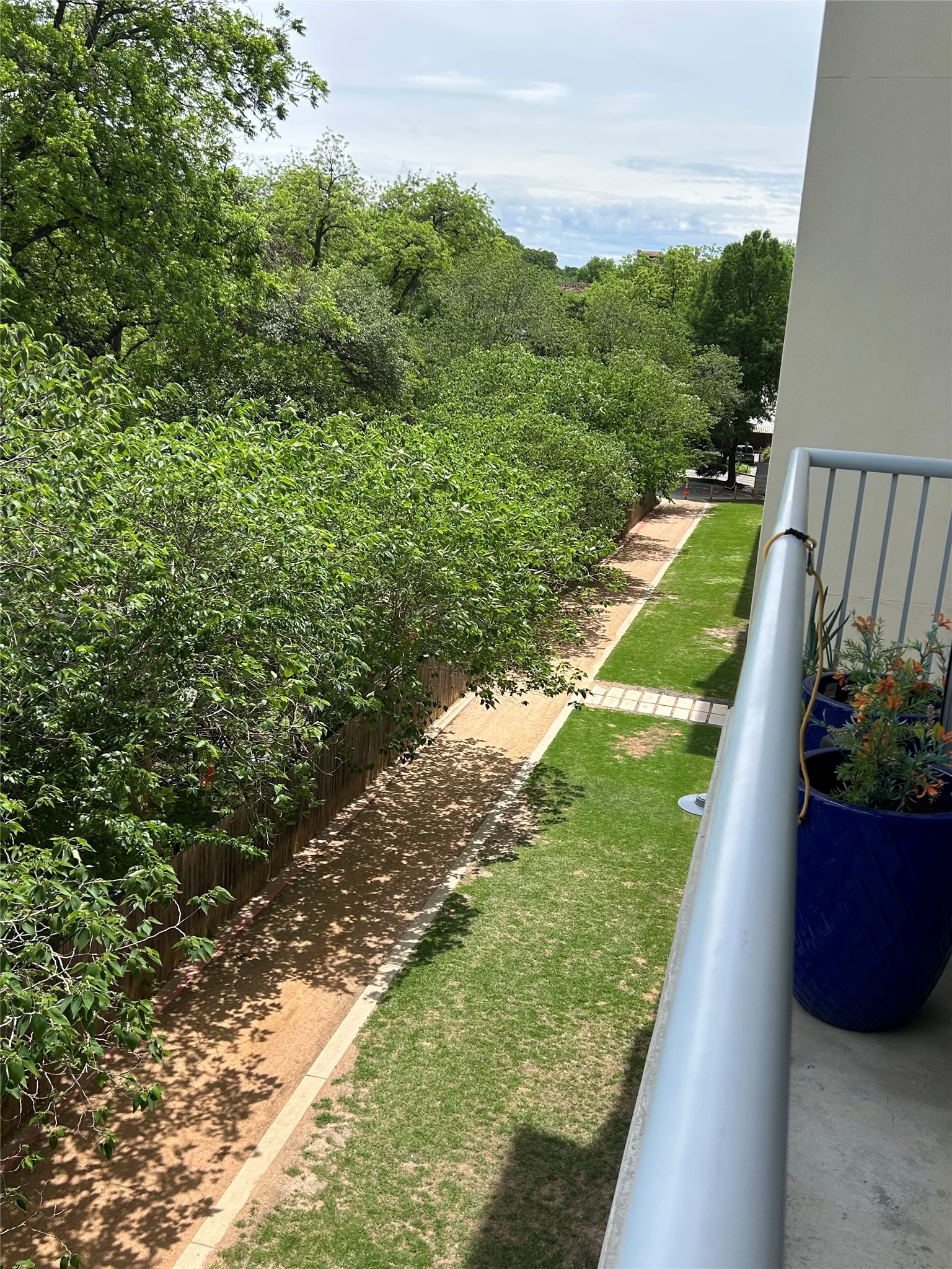 1600 Barton Springs Road, Unit 4305 Austin, TX 78704 - Photo 21 of 28 Balcony with metal railing overlooking a landscaped pathway