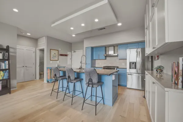 a large kitchen with stainless steel appliances granite countertop a stove a sink a dining table and chairs